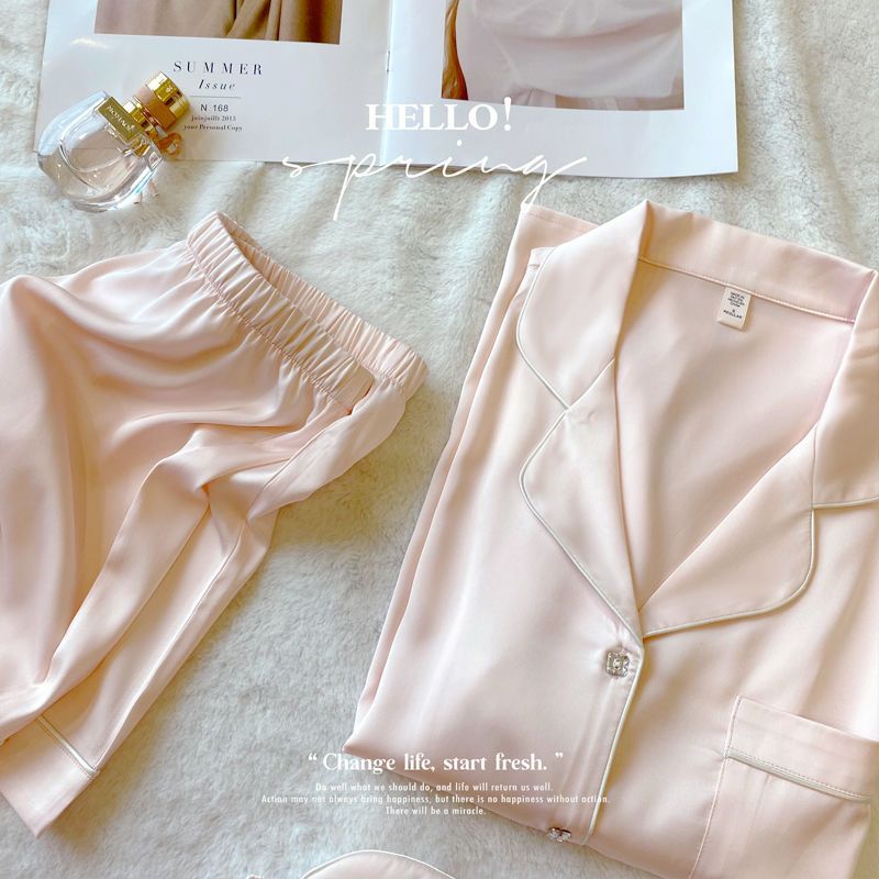 Pink pajama set with a magazine and perfume bottle on a light background