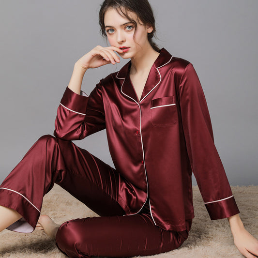 Woman wearing a burgundy satin pajama set on a gray background