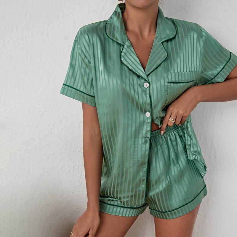 Green satin pajama set worn by a woman in front of a white background