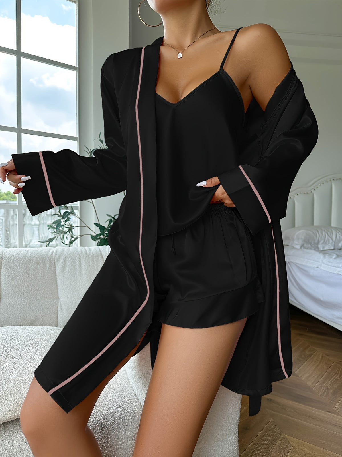 Person wearing a black outfit with pink trim in a bedroom setting